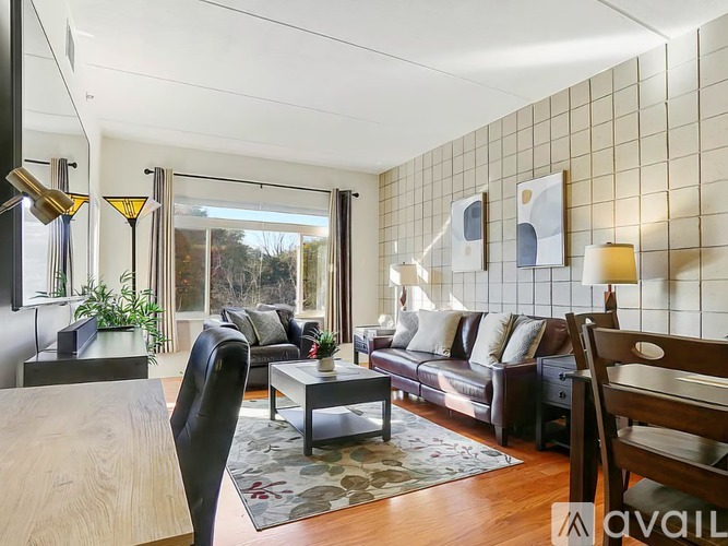 A living room with a black leather chair and a wooden coffee table.