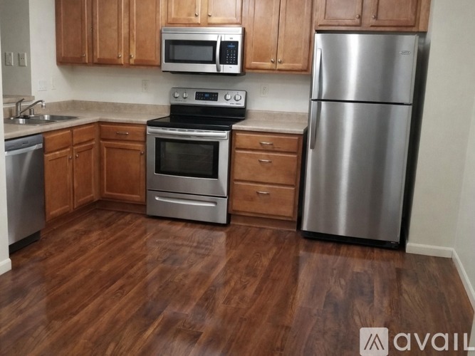 A kitchen with wooden cabinets and a stainless steel refrigerator.