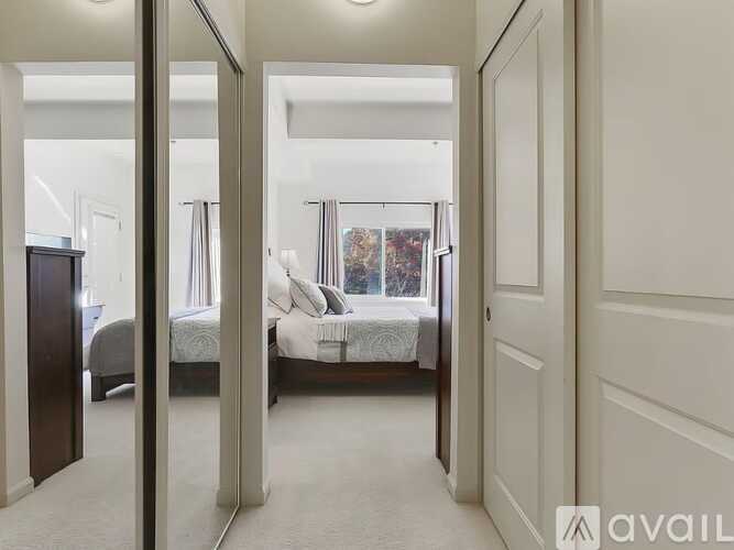 A bedroom with a large bed and a mirror on the wall.