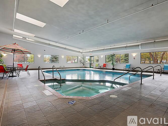 A large indoor swimming pool with a hot tub and a sun lounger.