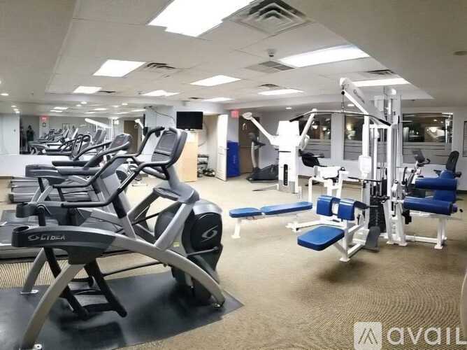 A gym with treadmills, weights, and exercise equipment.