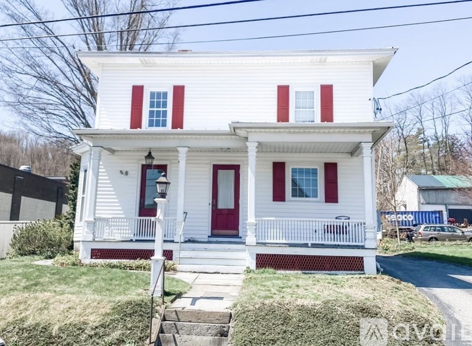 A white house with red shutters and a red door.