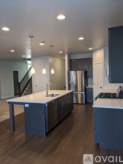 A modern kitchen with dark wood cabinets and stainless steel appliances.