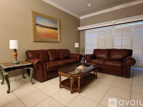 A living room with two brown leather couches and a coffee table.