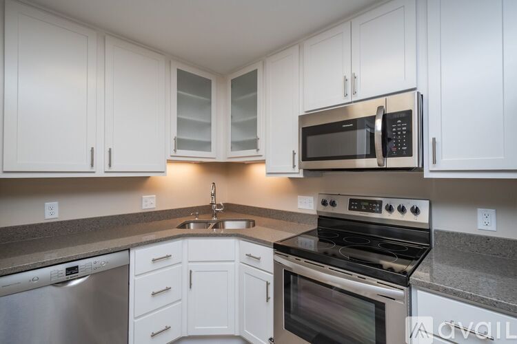 A modern kitchen with white cabinets and stainless steel appliances.