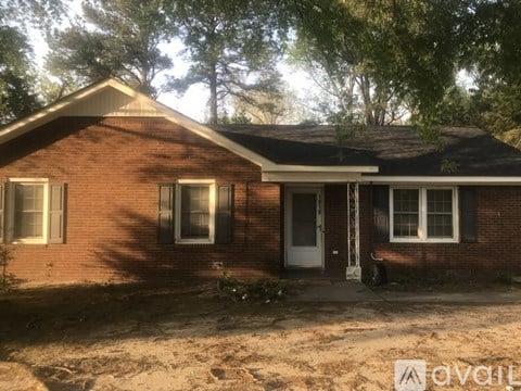 A brick house with a white door and windows is for sale.