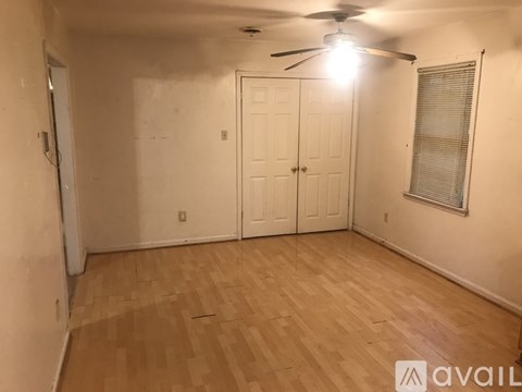 A room with a ceiling fan and wooden flooring.