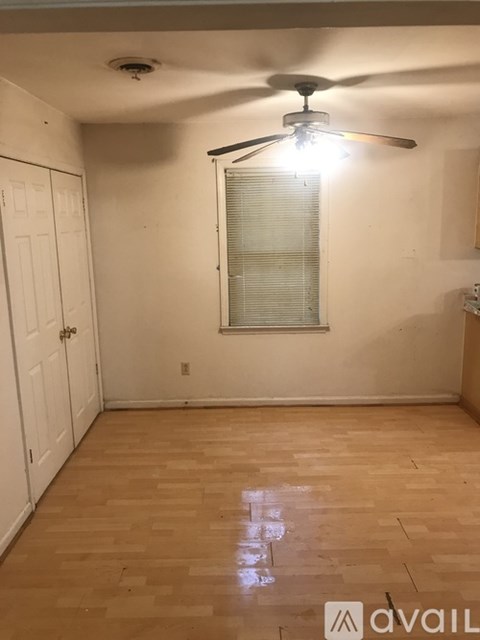 A room with a ceiling fan and wooden flooring.