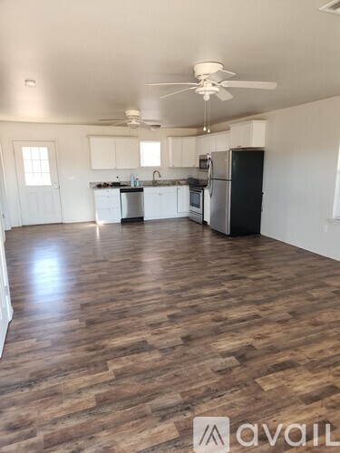 A room with wooden flooring and a door leading to a bathroom.