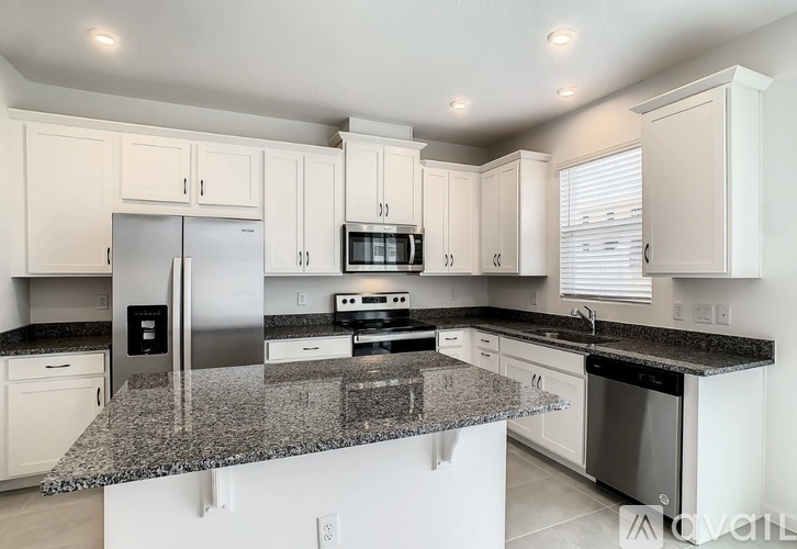 A kitchen with granite countertops and stainless steel appliances.