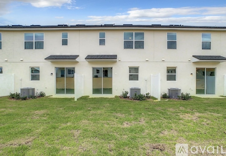 A row of townhouses with a grassy front yard.