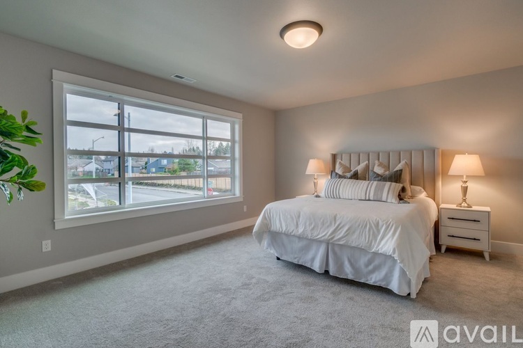 A bedroom with a large bed and a window overlooking a parking lot.