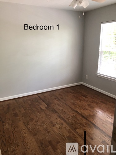 Bedroom 1 has wood flooring and a window.