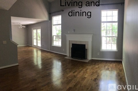 A living room with a fireplace and a dining area with a table and chairs.