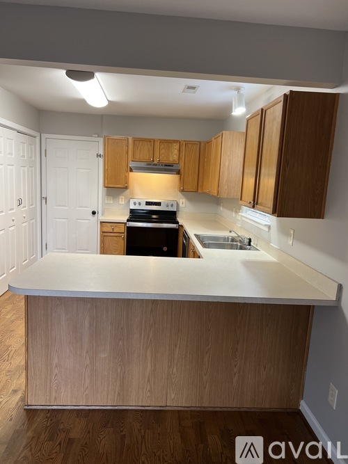 A kitchen with wooden cabinets and a white countertop.