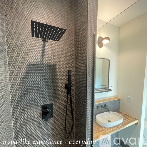 A modern bathroom with a shower and a sink.