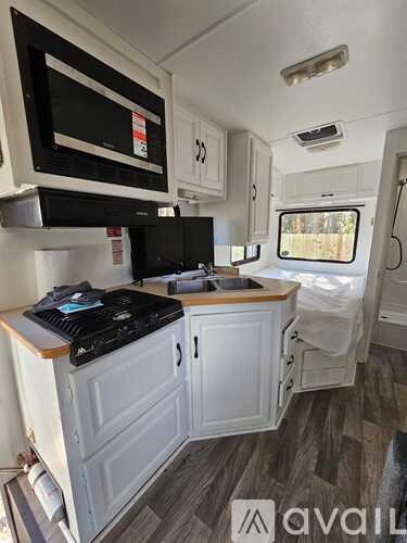 A small kitchen with a black stove top oven and white cabinets.