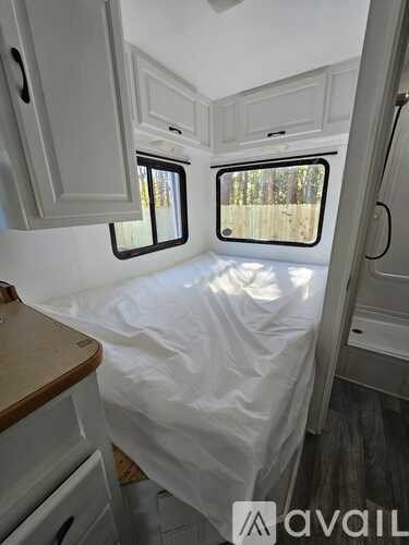 A white RV with a bed and a window.