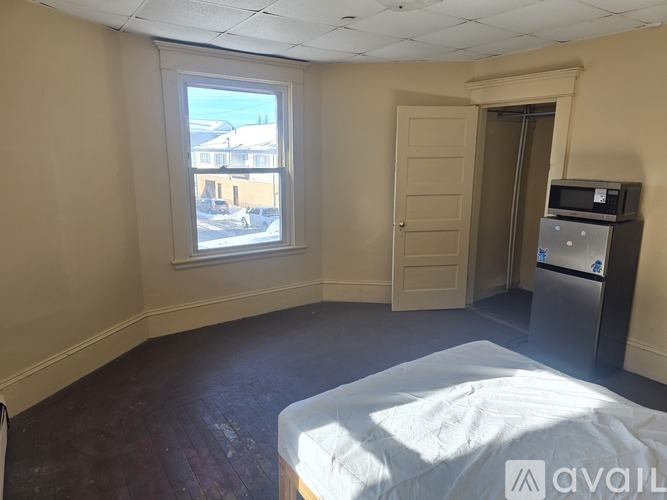 A room with a bed, a window, and a door.