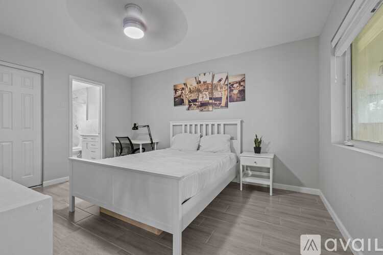 A bedroom with a large bed and a small nightstand.