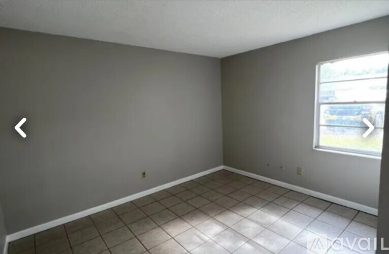 A room with grey walls and a window showing a street view.