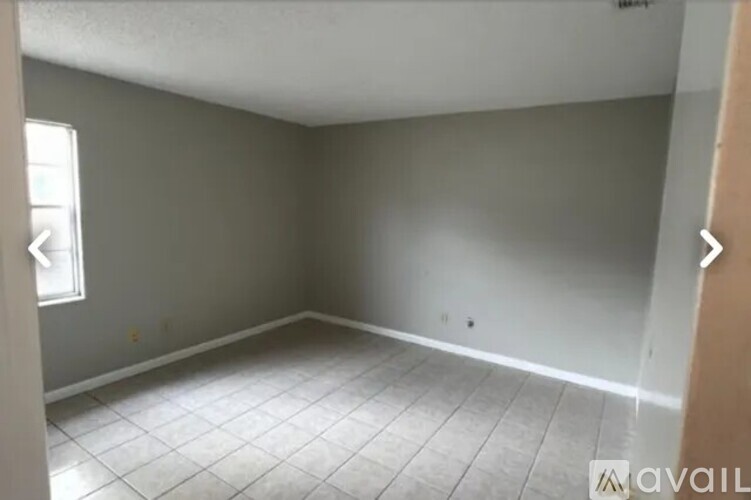 A room with a tiled floor and a window on the left side.