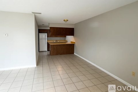 A kitchen area with a refrigerator, sink, and countertop.