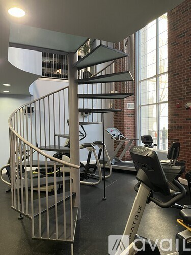 A gym with a variety of equipment including dumbbells, weight plates, and a medicine ball.