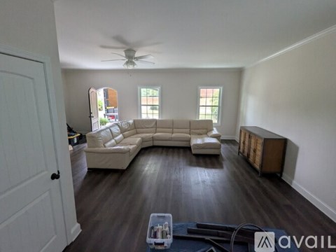 A living room with a white couch and a ceiling fan.