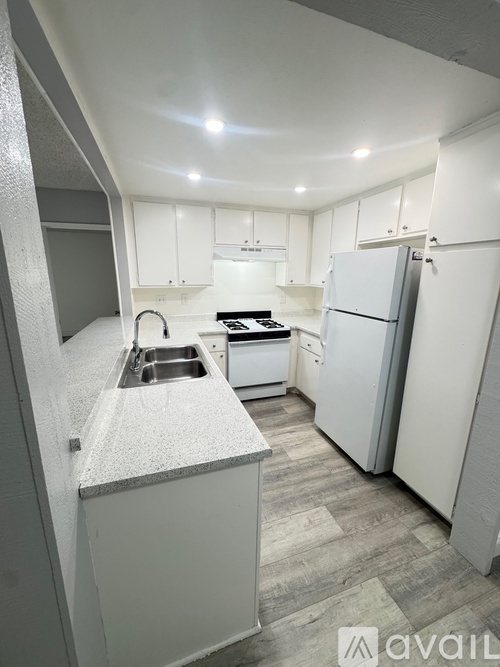 A kitchen with white cabinets and a grey island.