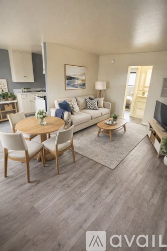 A spacious room with a ceiling fan and a kitchenette.