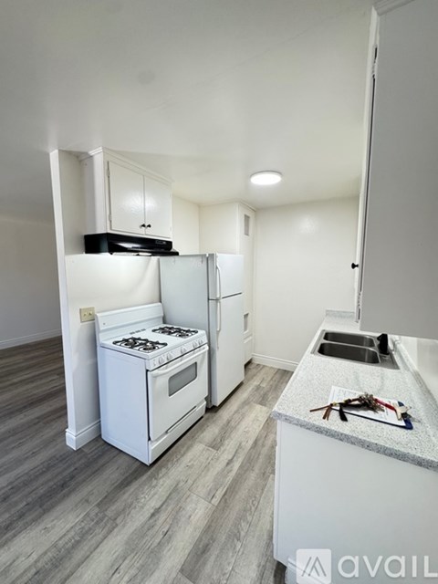 A room with a ceiling fan and light, and a door on the left.