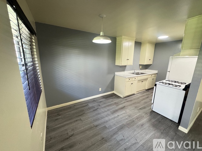 A kitchen area with a white dishwasher and a white fridge.