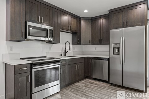 A kitchen with dark wood cabinets and stainless steel appliances.