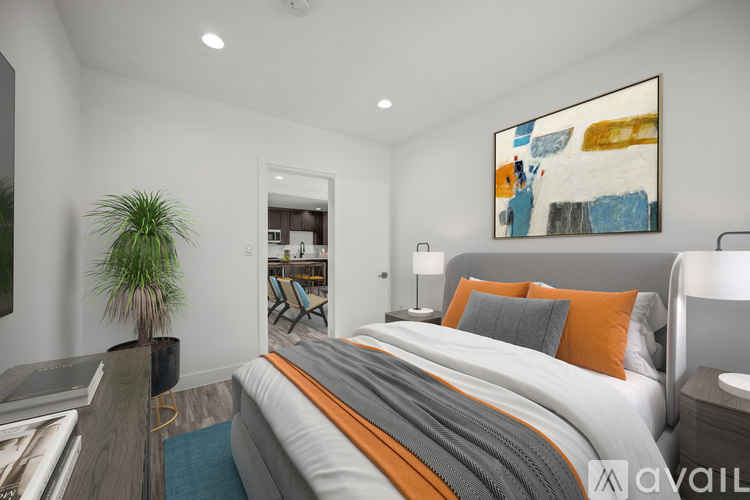A bedroom with a large bed and a painting on the wall.