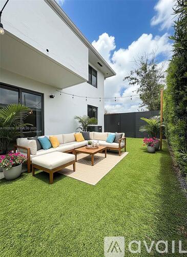 A modern outdoor seating area with a white couch and wooden coffee table.