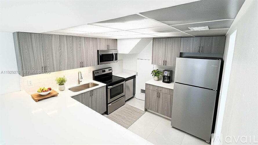 A modern kitchen with a refrigerator, sink, and oven.