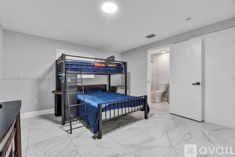 A bedroom with a bunk bed and a toilet in the background.