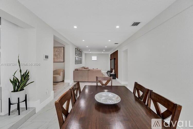 A modern dining room with a wooden table and chairs.