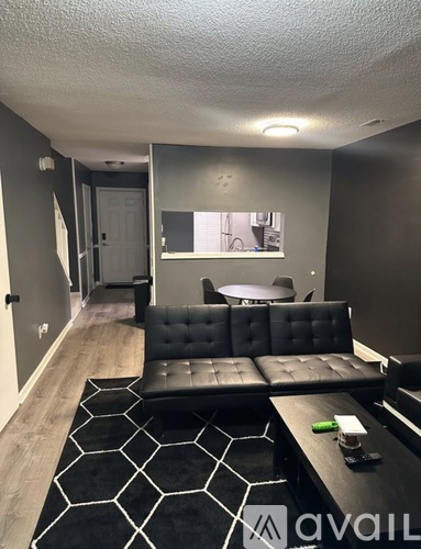 A black and white living room with a large couch and a rug.