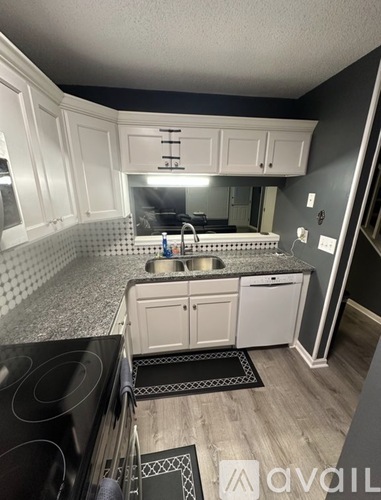 A kitchen with black countertops and white cabinets.