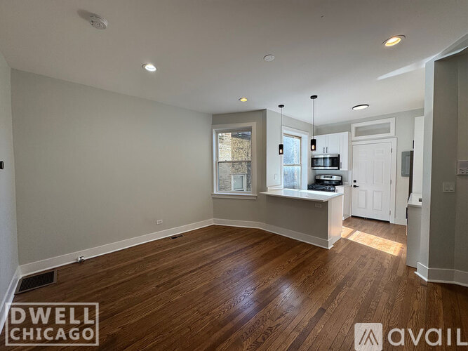 A spacious room with wooden floors and white walls.