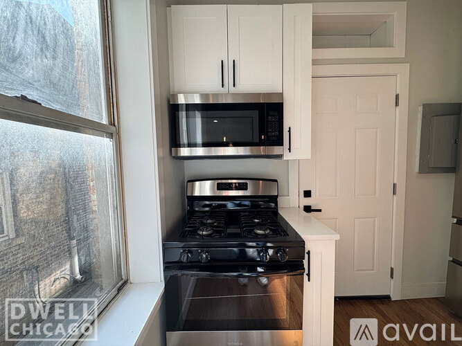 A kitchen with a stove and microwave above it.