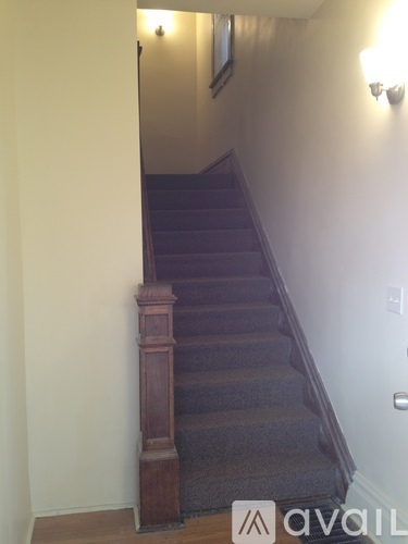 A staircase with a carpeted runner and wooden balusters.