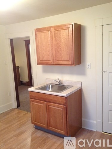A kitchen with wooden cabinets and a white sink.