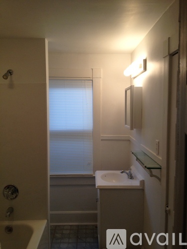 A bathroom with a sink, mirror, and light fixture.