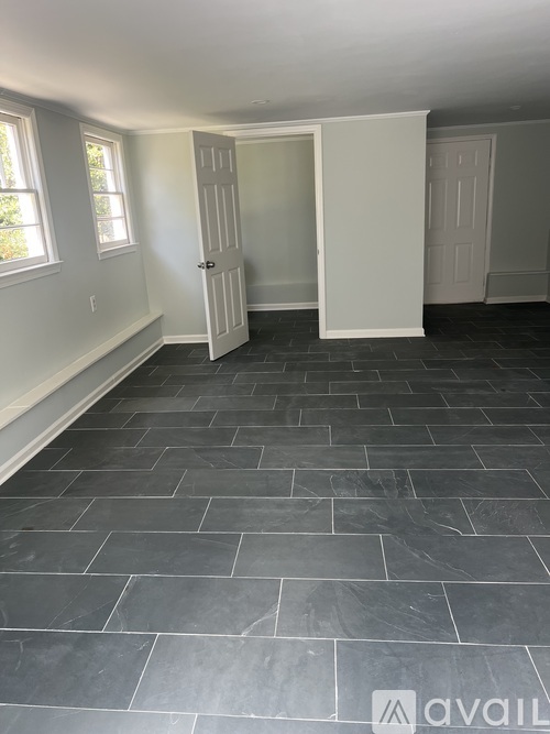 A room with a slate tile floor and a white door.