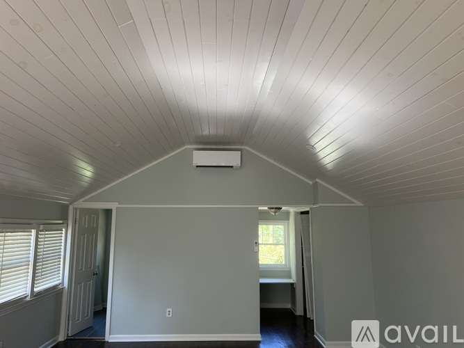 A room with a white ceiling and a window with blinds.