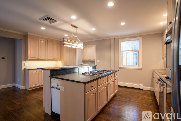 A kitchen with wooden cabinets and a black countertop.
