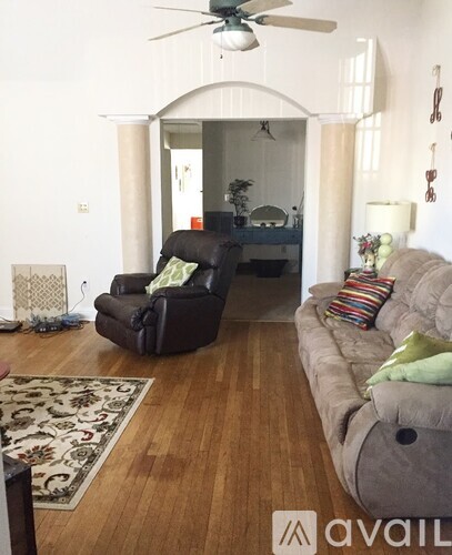 A living room with a black chair and a grey couch.
